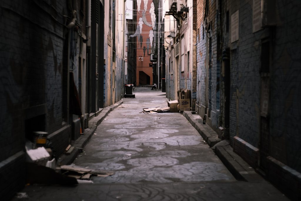 A narrow alley way with a flag hanging from the ceiling