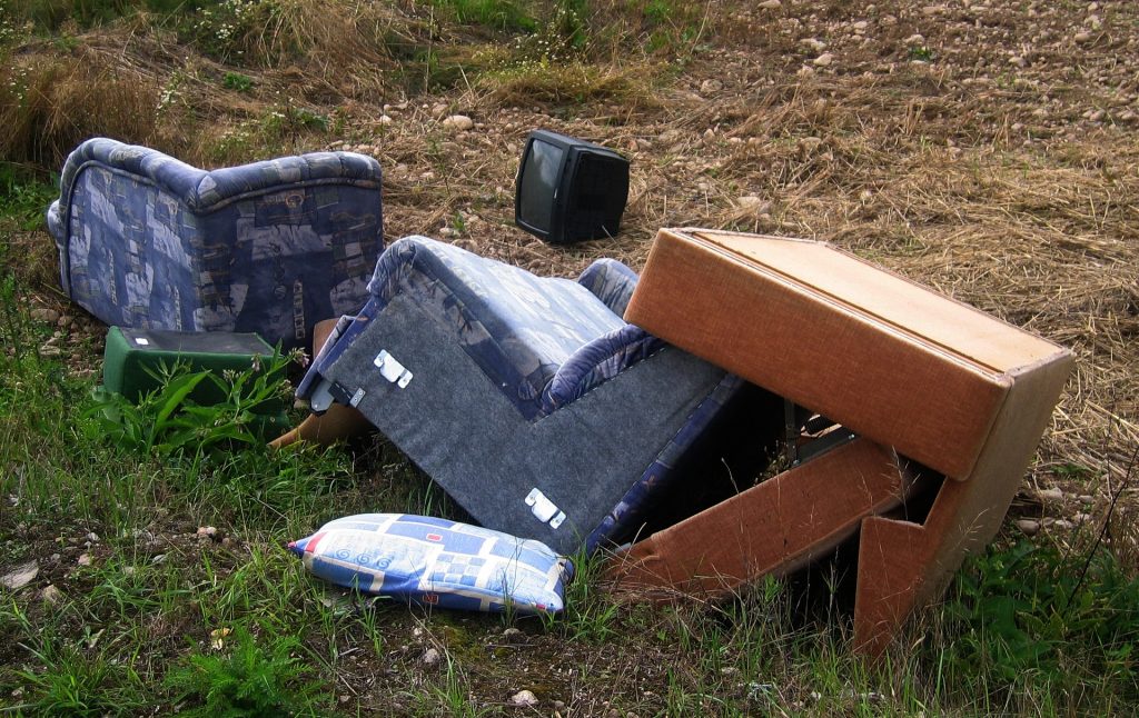 A pile of furniture sitting on top of a grass covered field