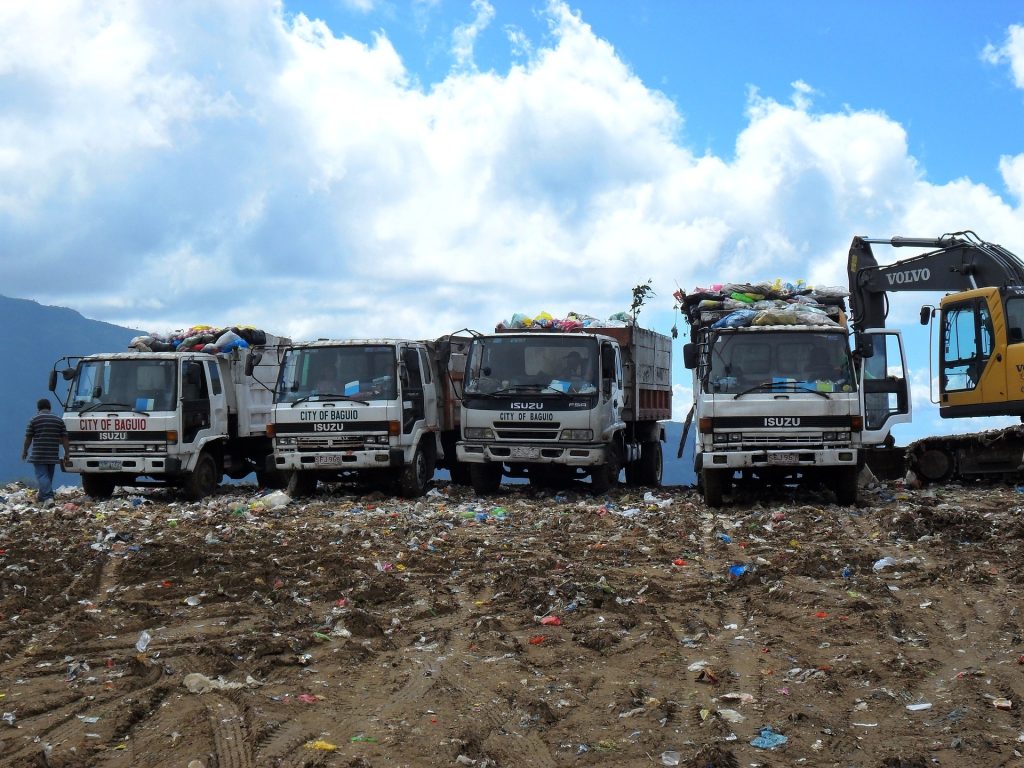 A group of trucks parked next to each other on a dirt field