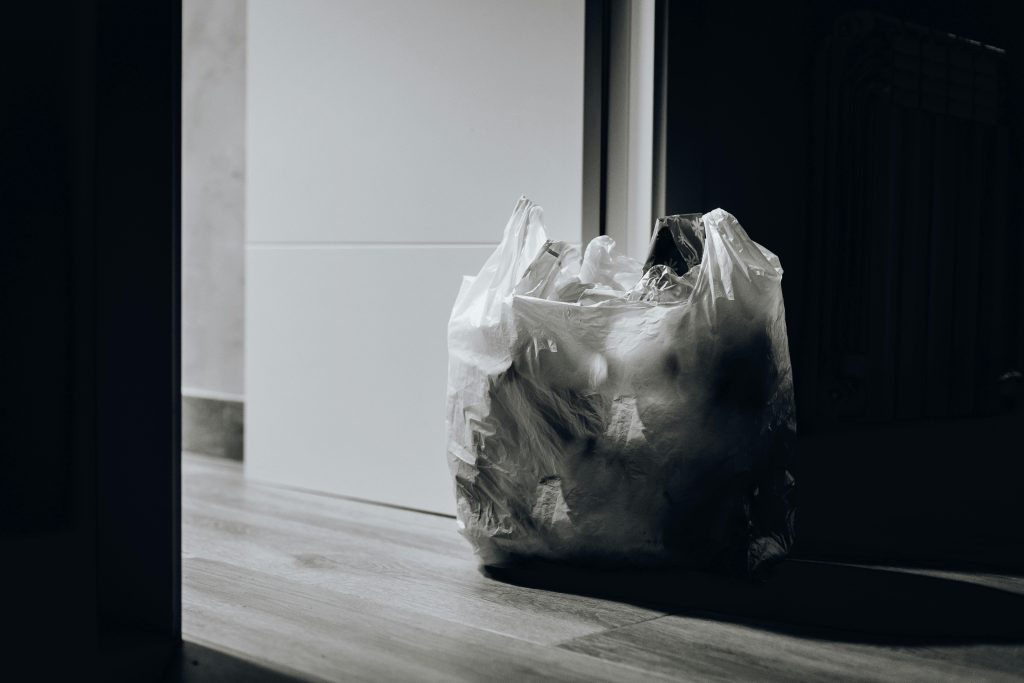 A black and white photo of a plastic bag on the floor